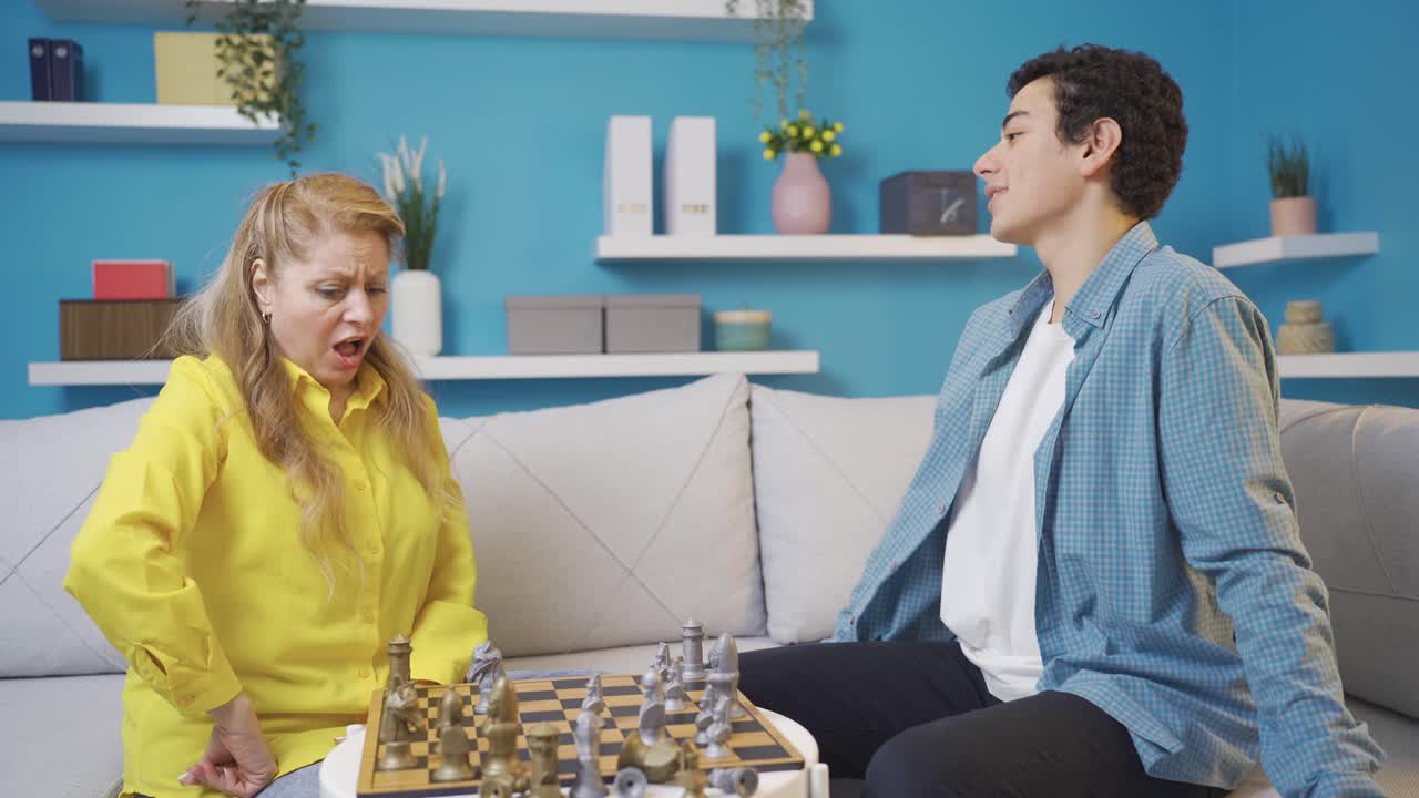 y una madre y un hijo lindos jugando al ajedrez en su casa moderna.