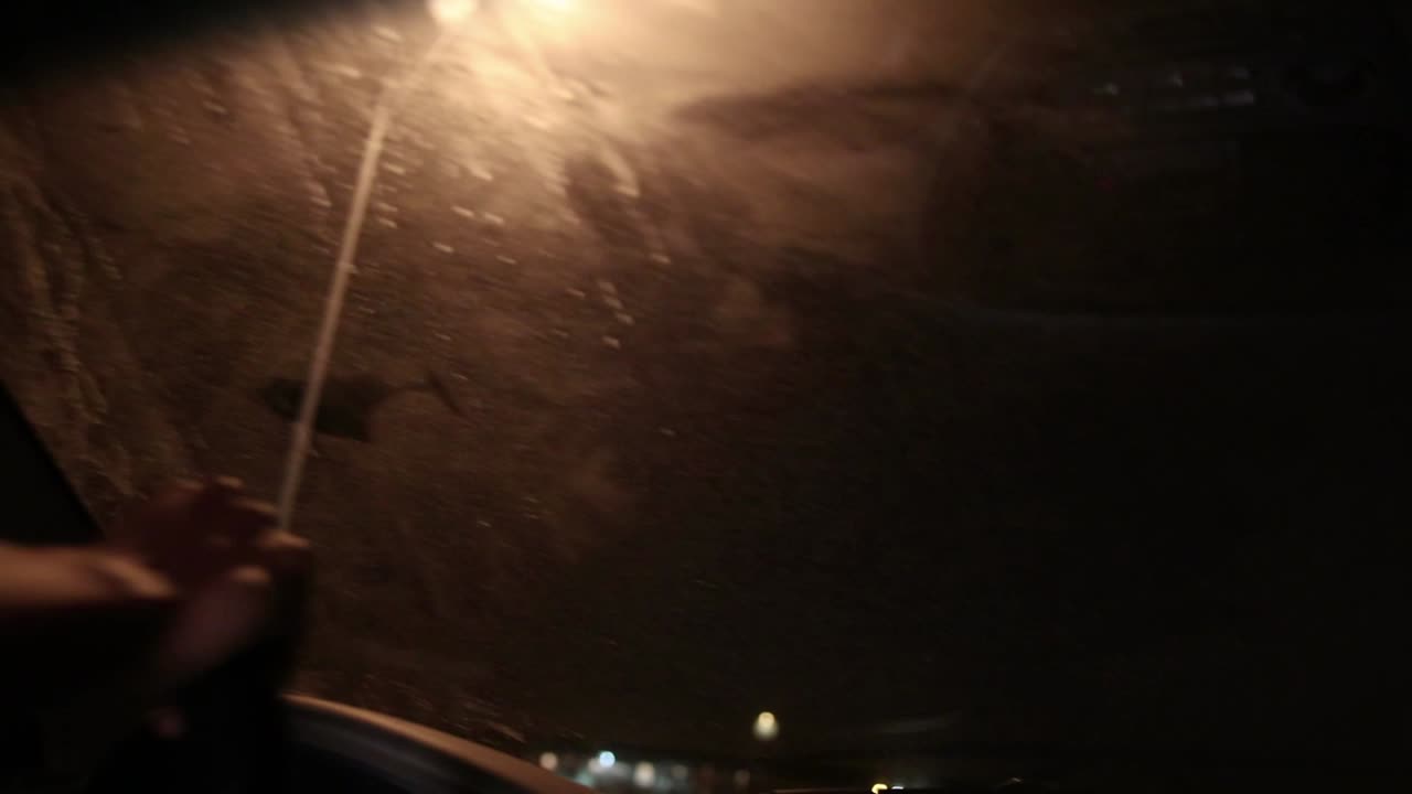 joven afroamericano negro golpea algo mientras conduce por la noche y se asusta