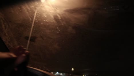 joven afroamericano negro golpea algo mientras conduce por la noche y se asusta