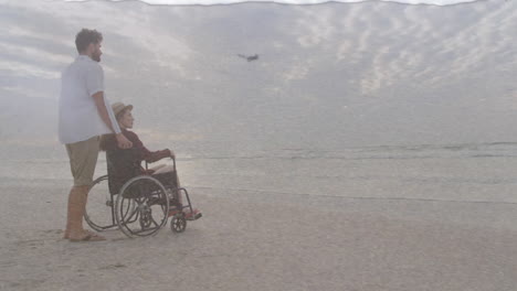 animation of sea over caucasian man with woman in wheelchair