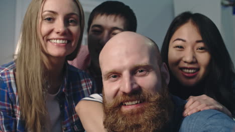 group of coworkers smile and wave while looking closely at the camera