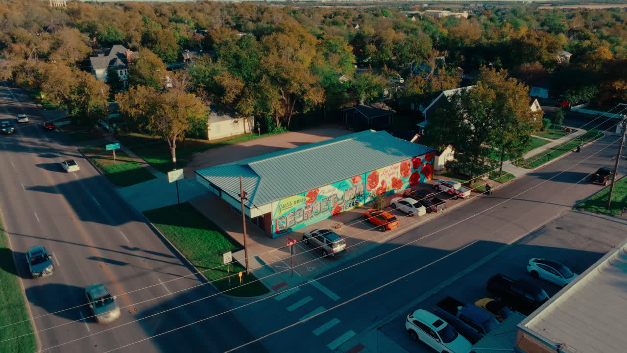 Aerial drone pull away from corner drugstore "Greetings from Georgetown" mural in Austin suburb Georgetown, Texas
