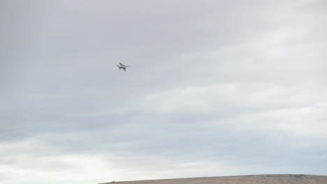 Zeitlupenansicht-Eines-Kampfjets,-Der-In-Den-Wolken-über-Einer-Schlucht-Fliegt