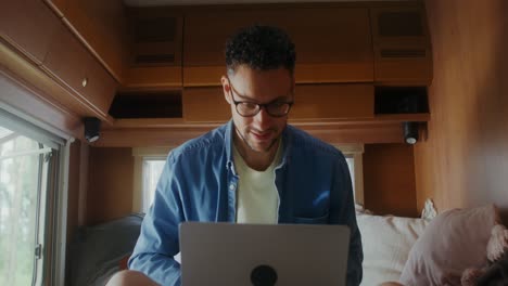 hombre trabajando en una computadora portátil en una caravana