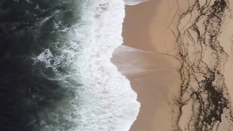 arial shot of a beach and ocean waves