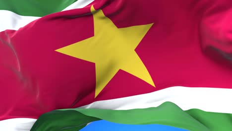 suriname flag waving at wind in slow in blue sky, loop