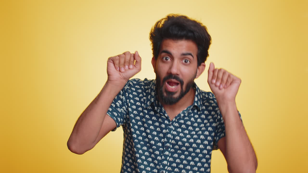 Cheerful funny bully indian man showing tongue making silly faces fooling around joking teasing