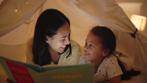 mother and daughter reading together in a tent