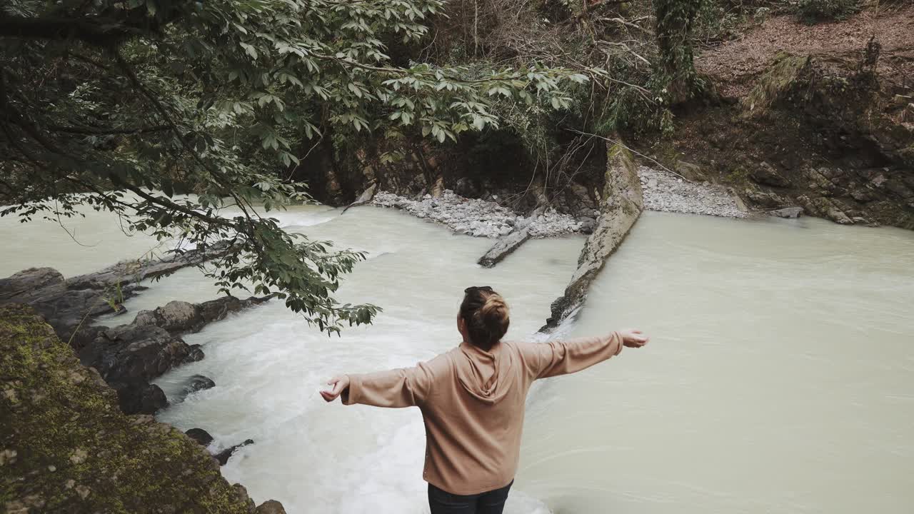 조용 한 숲 에서 경치 좋은 폭포 전망 을 즐기는 여자