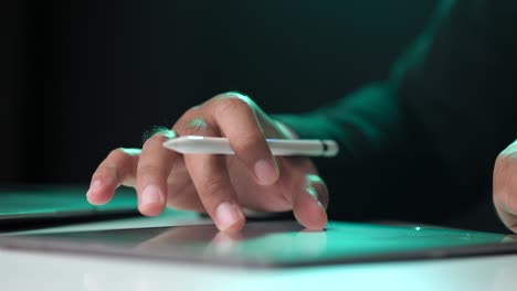 electronic signature with green light. businessman signing a business contract with stylus pen on tablet at night. man signing contract on tablet at office. business and technology concept.