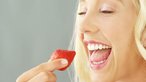 close-up of beautiful woman eating strawberries in bowl
