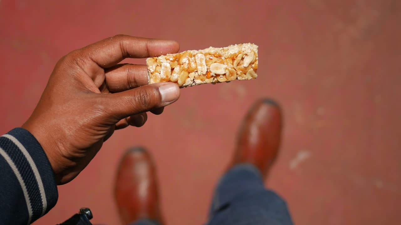 Person Holding a Peanut Bar