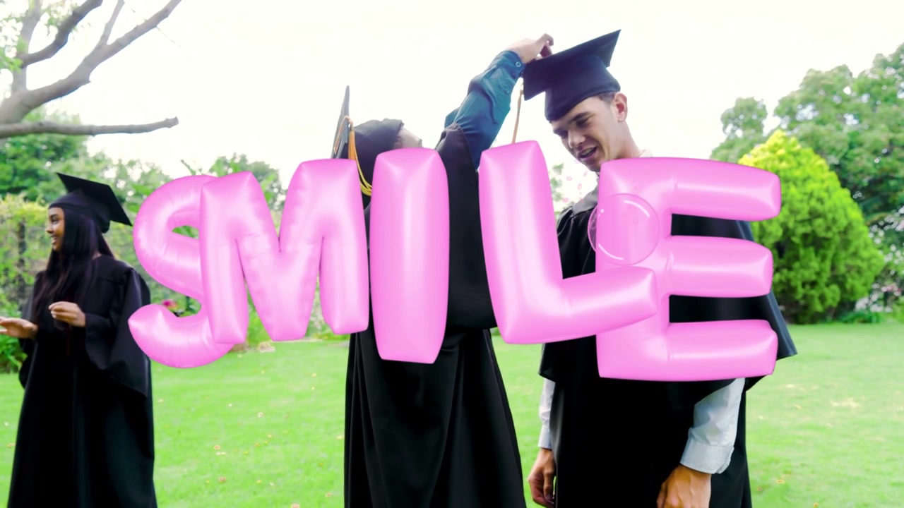 Vrouw komt links binnen en begroet man die kwastje van afstudeerhoed aanpast onder roze 3D SMILE-overlay.