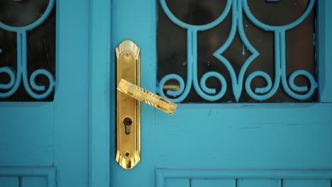 gold door handle and lock on traditional ornate blue door, chefchaouen