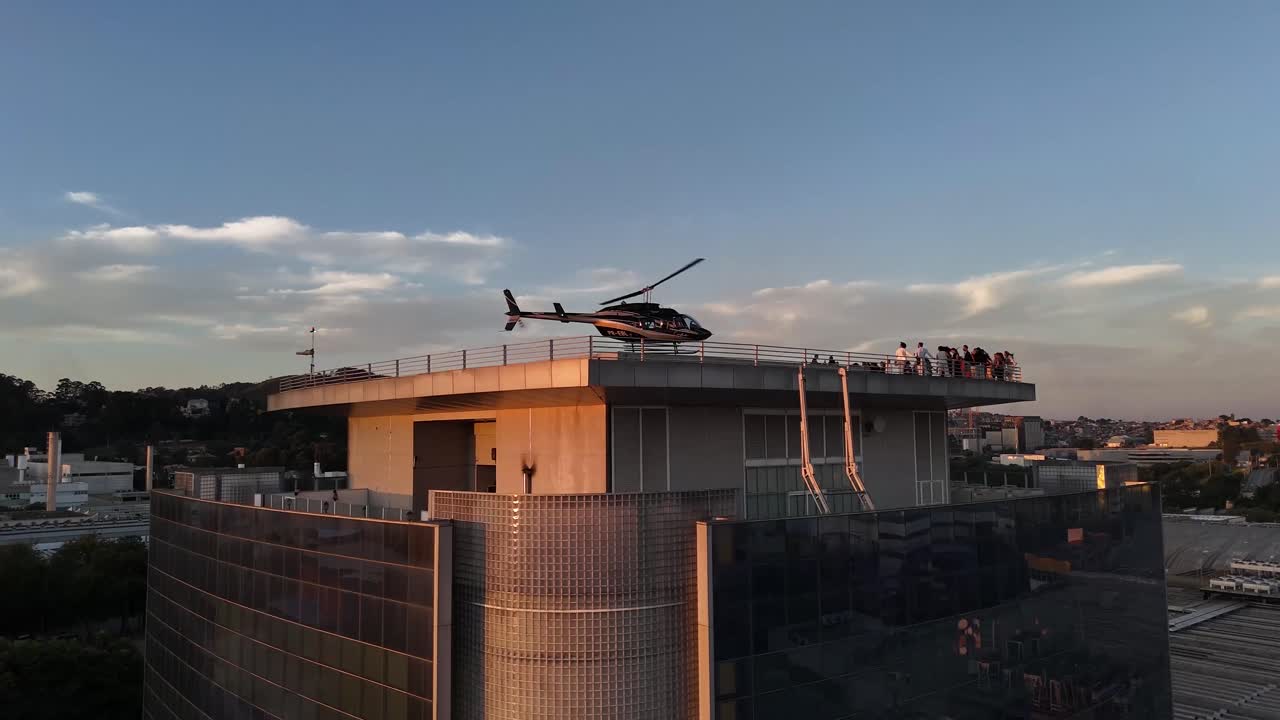 Helicopter on a modern building rooftop helipad at sunset or sunrise