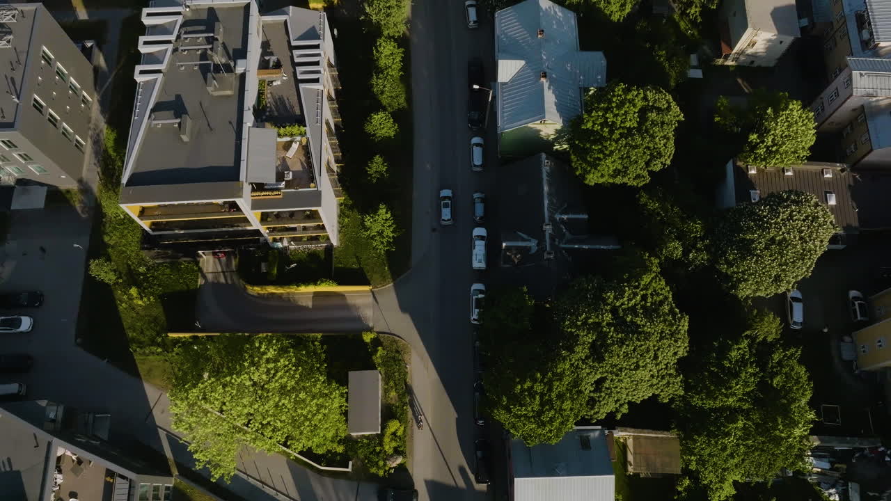 Aerial tilt shot following a car driving in the suburbs, toward downtown Tallinn