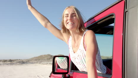 Junge-Kaukasische-Frau-Genießt-Einen-Sonnigen-Tag-Am-Strand-Von-Ihrem-Auto-Aus-Auf-Einem-Roadtrip