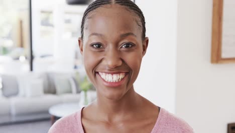 Portrait-of-happy-african-american-woman-smiling-in-living-room-at-home,-in-slow-motion