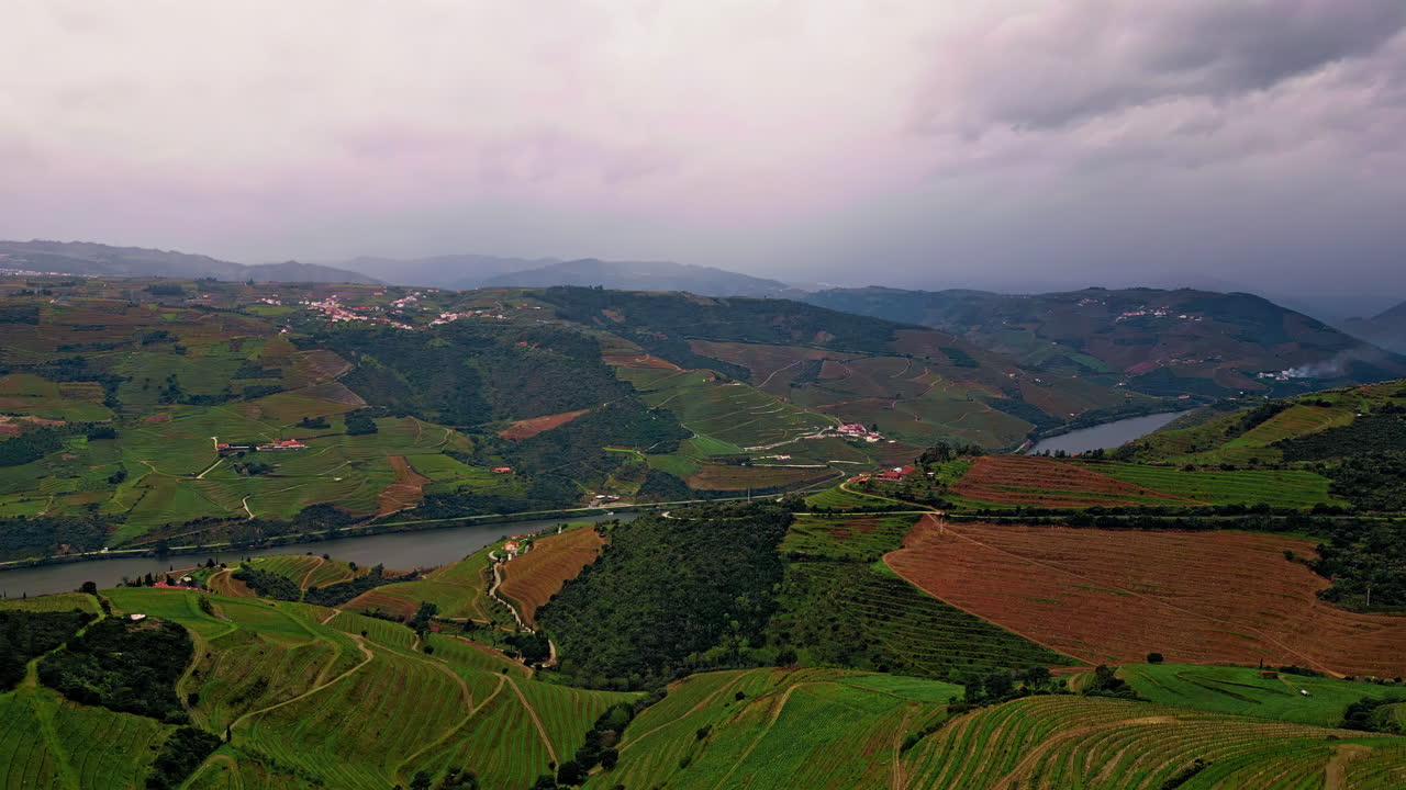 Campi coltivati sparsi su verdi colline, vista aerea. Fiume calmo che scorre nella valle