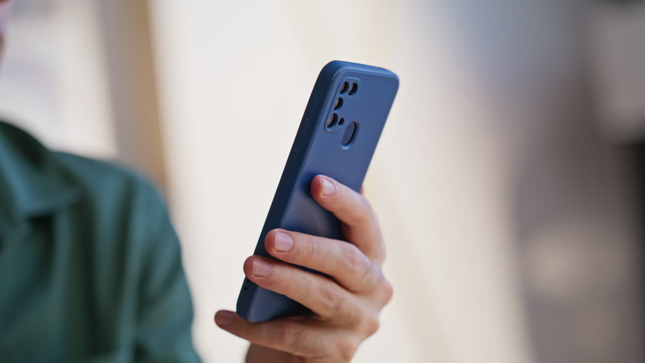 Closeup man watching cellphone content in apartment. Portrait office businessman