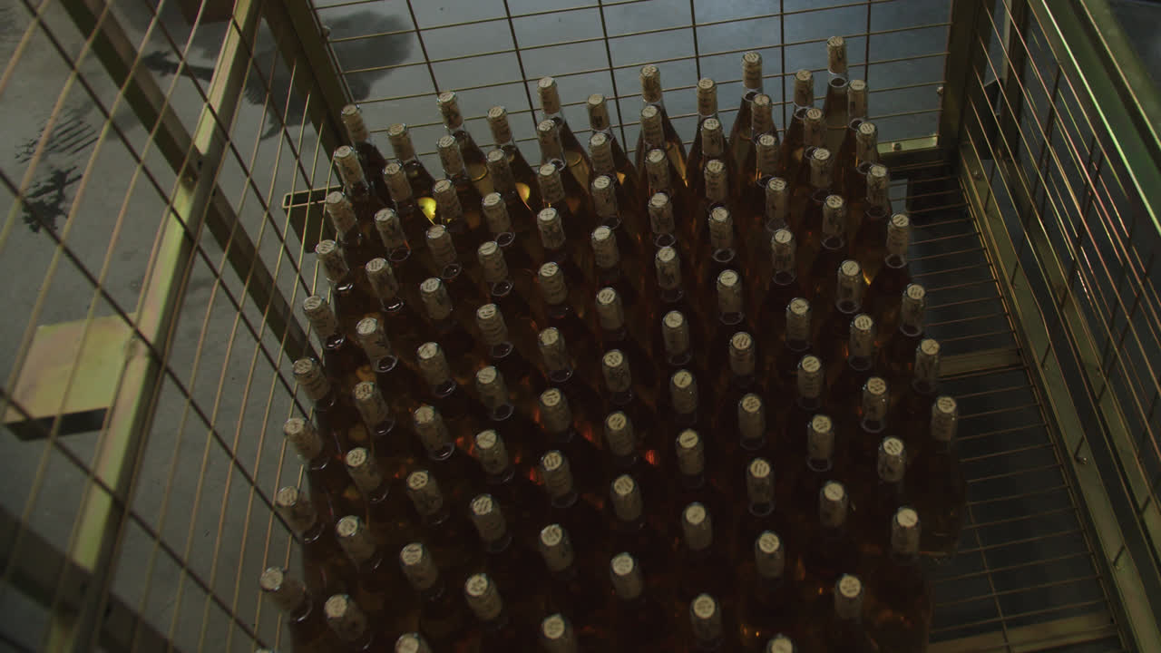 Amazing wide shot of machinery that fills wine bottles inside a wine factory in Burgos, Spain in 4k