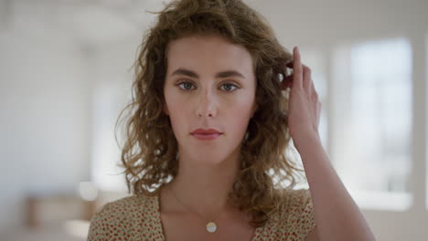 portrait of attractive young woman looking at camera running hand through hair calm attractive independent female student real people series