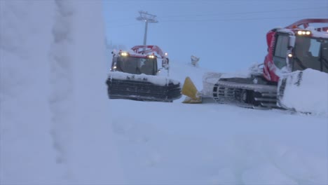 snow groomer working on skiing slope in winter, beautiful weather in the alps