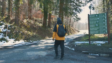 The-hiker-passes-by-and-looks-at-the-signpost-on-the-mountain-4K