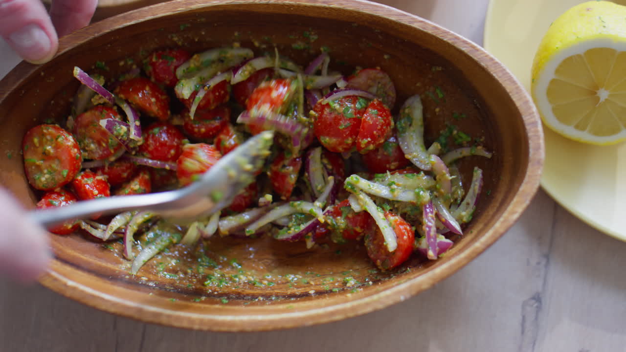 Mixing Tomato Salad with Dressing