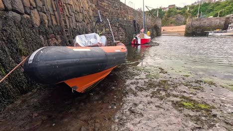 boat in harbor, tide receding, revealing muddy ground