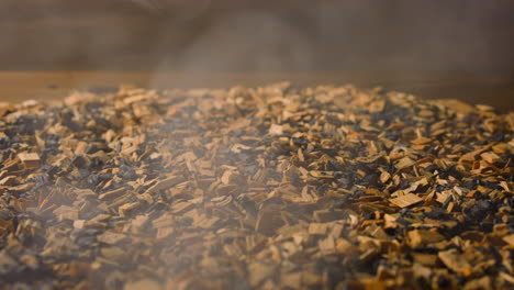 wooden chips and hot charcoals with light steam in smokery