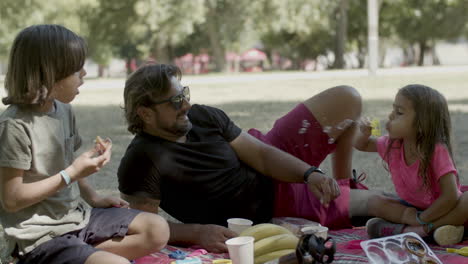 padre soltero haciendo picnic con niños en la naturaleza