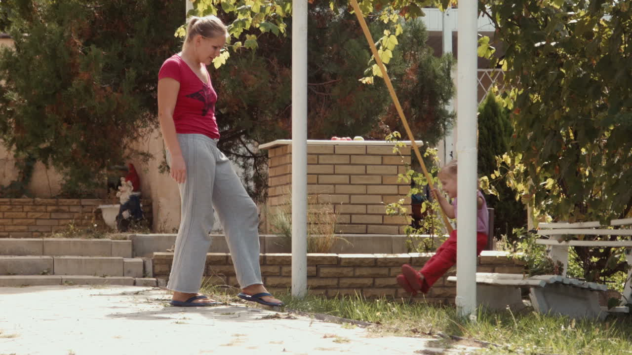 Mother and daughter enjoying a swing set in the park