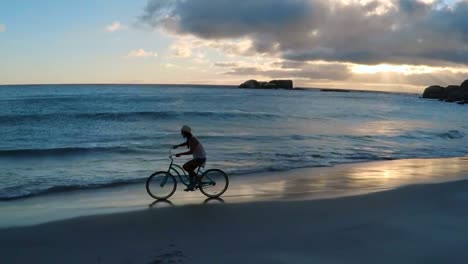 Woman-riding-bicycle-on-the-beach