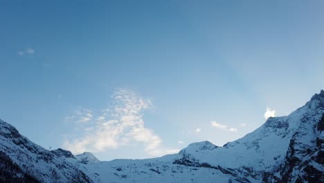 Timelapse-En-Movimiento:-Noche-En-Saas-Fee-Con-Un-Cielo-Azul-Y-Nubes-Raras-Sobre-Las-Altas-Montañas-Nevadas