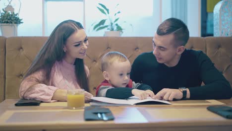 family-sits-at-brown-wooden-table-and-communicates