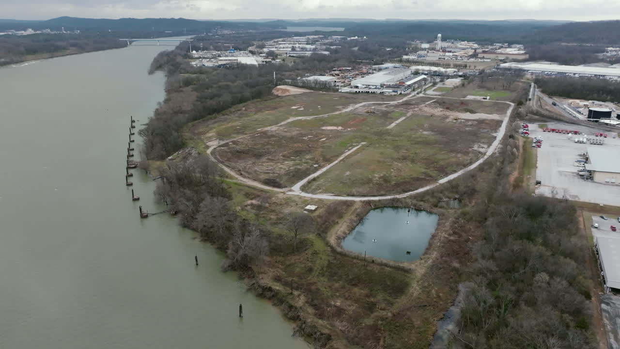 Wide aerial footage of a EPA superfund site in Chattanooga, TN that is abandoned where the camera rotates around it.