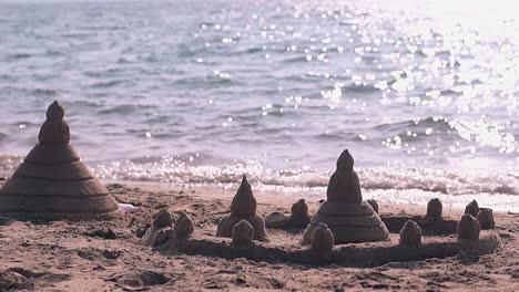 sand castle built on beach and rolling waves slow motion