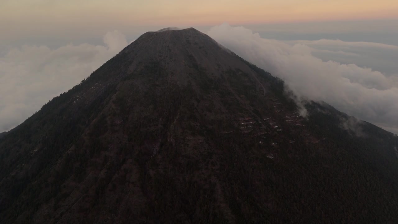 Rekaman udara megah yang menangkap puncak Gunung Agung di Bali di atas awan saat fajar