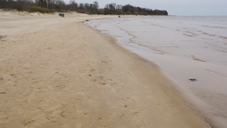 walking alongside baltic sea sandy coastline on moody day