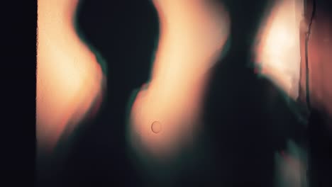 shadowy figures behind a textured surface