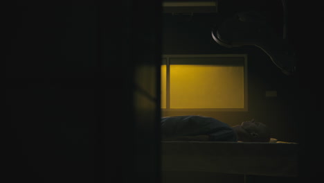 a bald man wakes up in the empty operation room