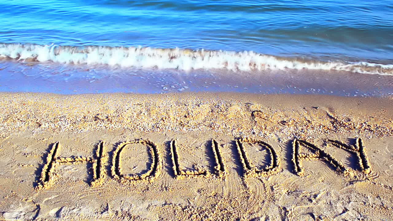 Inscription Holiday on sand, the beach. Shooting on the beach