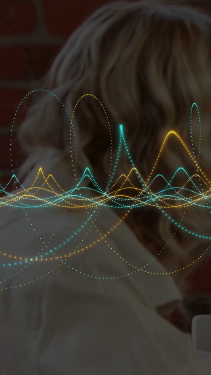 Vertical video: Teen and man at table audio playing causing tech wave pulsing across faces and mug