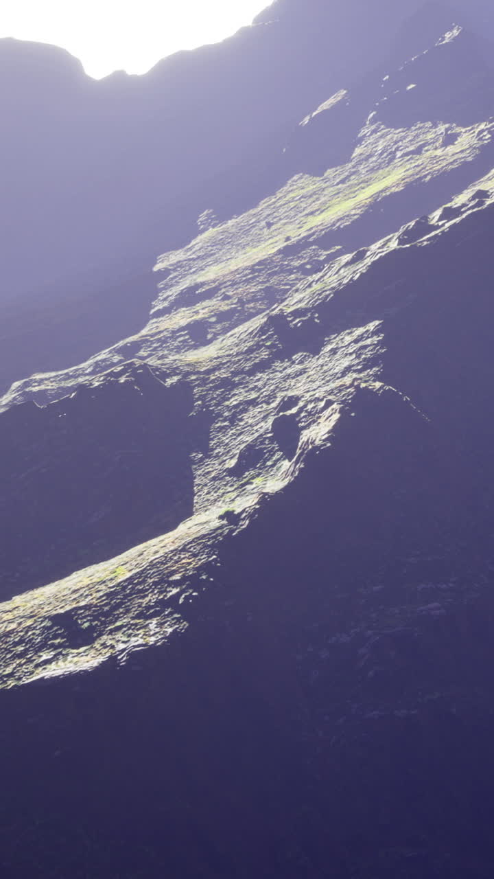 Luce solare che colpisce i versanti montuosi durante l'ora d'oro in un paesaggio naturale.