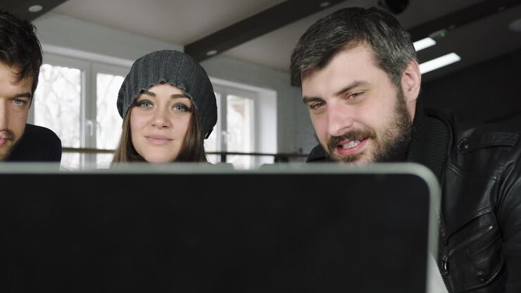 Team of young professionals having a conference call in a creative office. Business discussion. Coffee cups on the table. Shot in 4k