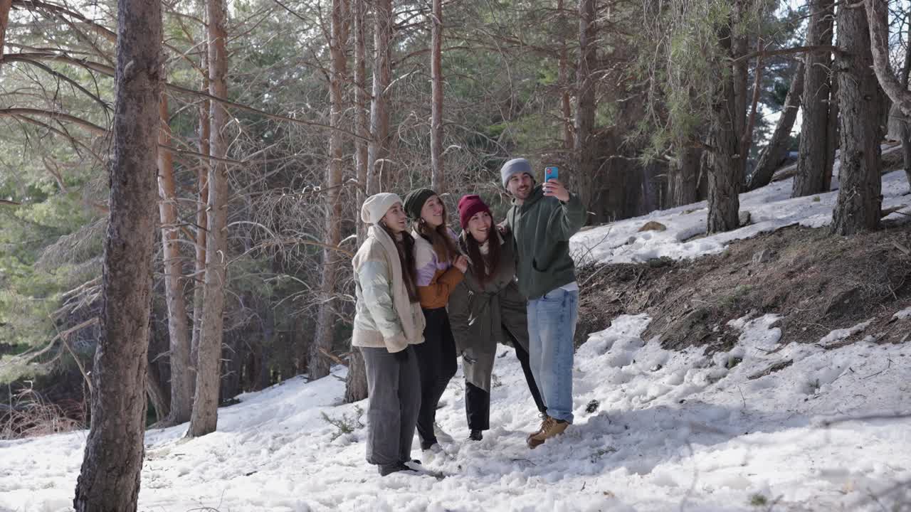 Group of friends taking a selfie in the snowy forest