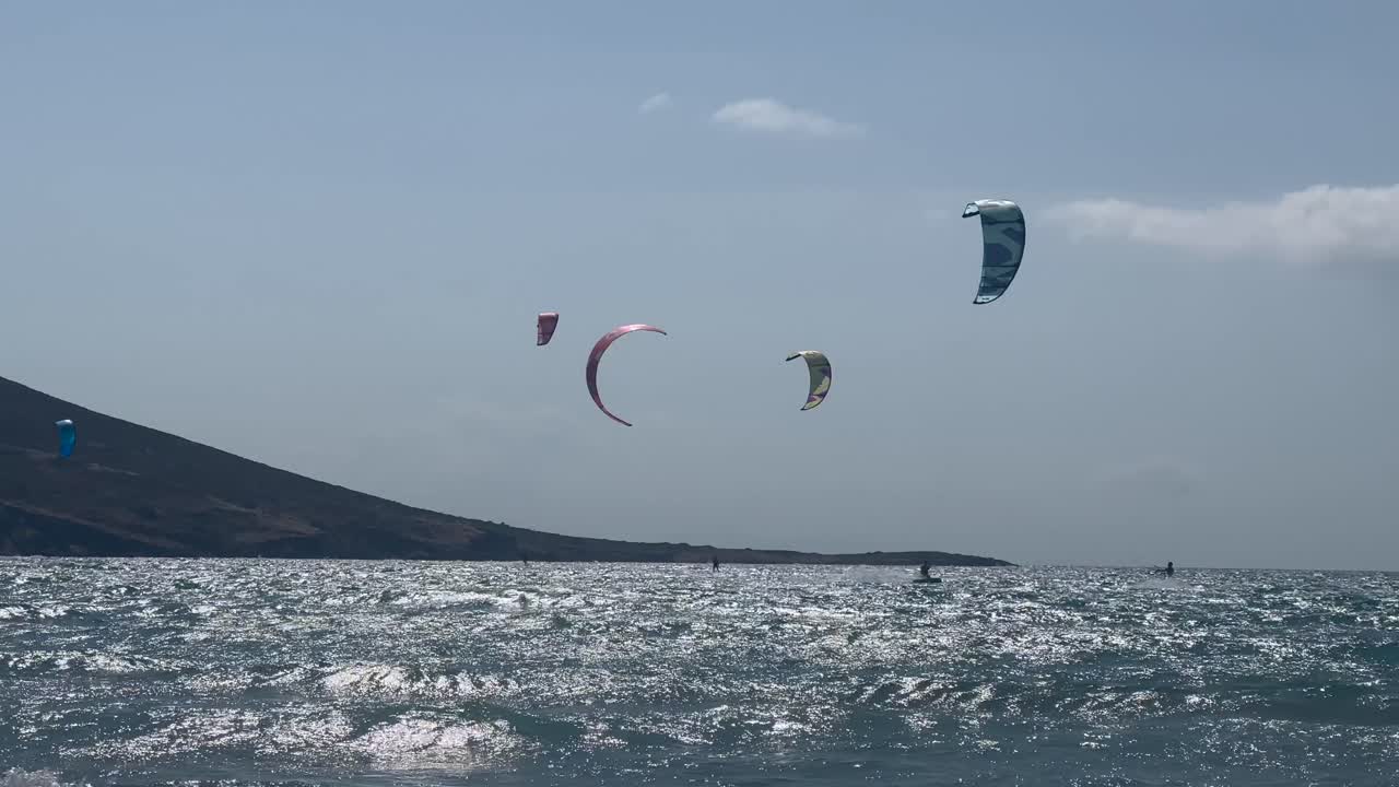 un gran grupo de kitesurfistas en el mar agitado cerca de la costa de paralia prasonisiou, rodas
