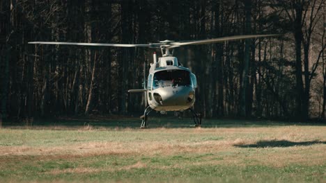 a helicopter slowly takes off in a field