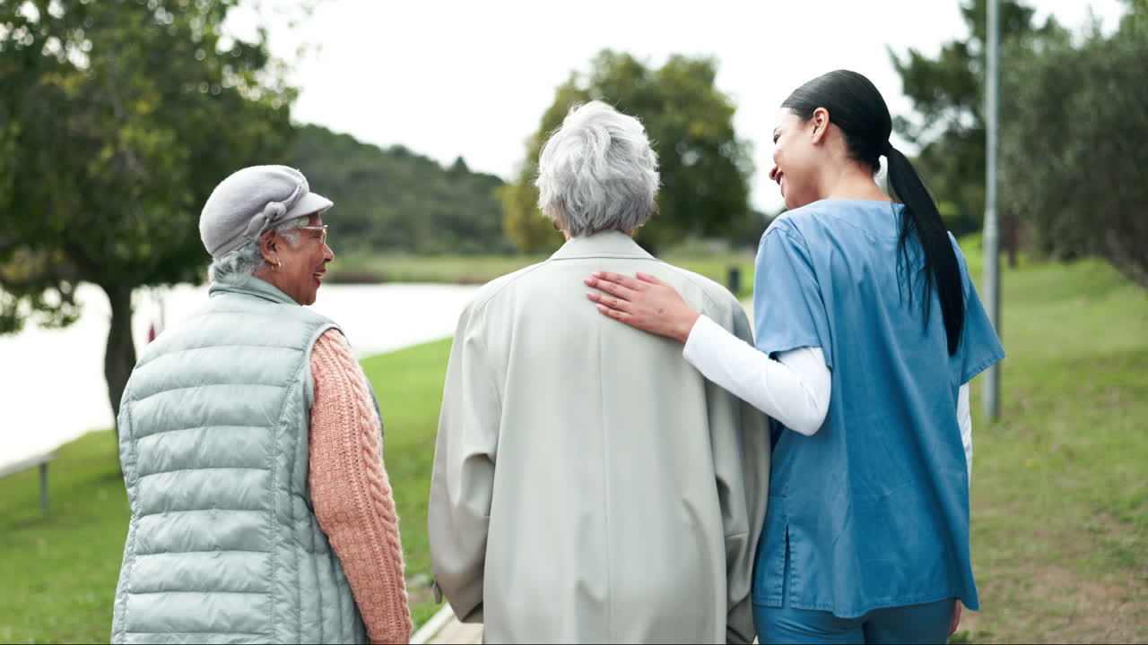 Caregiver walking with senior women outdoors